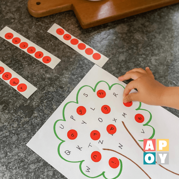 child hand putting red dot sticker on paper