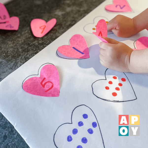 childs hands matching heart post it notes with numbers to dots