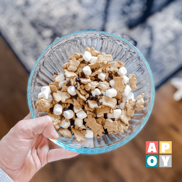 hand holding glass bowl with smores trail mix