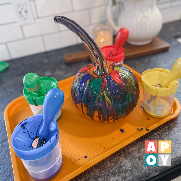 painted pumpkin and paint cups on art tray