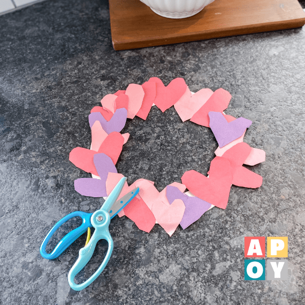 paper heart wreath on kitchen counter with toddler training scissors