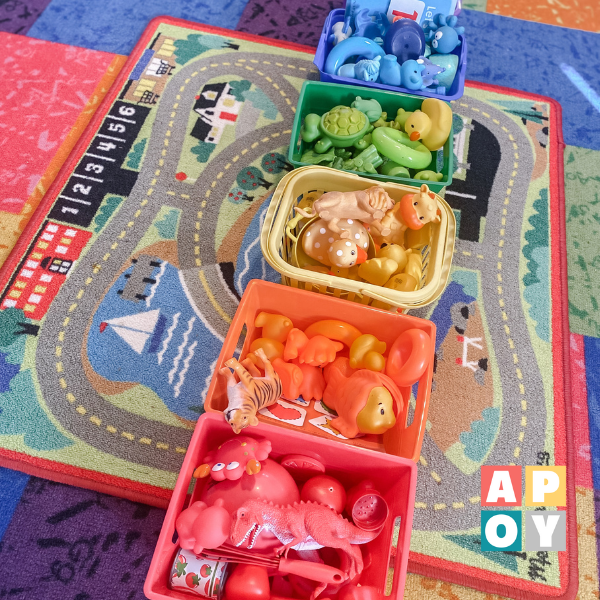 rainbow colored bins organized with kids toys on playroom floor