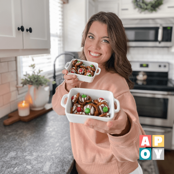 woman holding bowls of christmas chocolate treats in kitchen